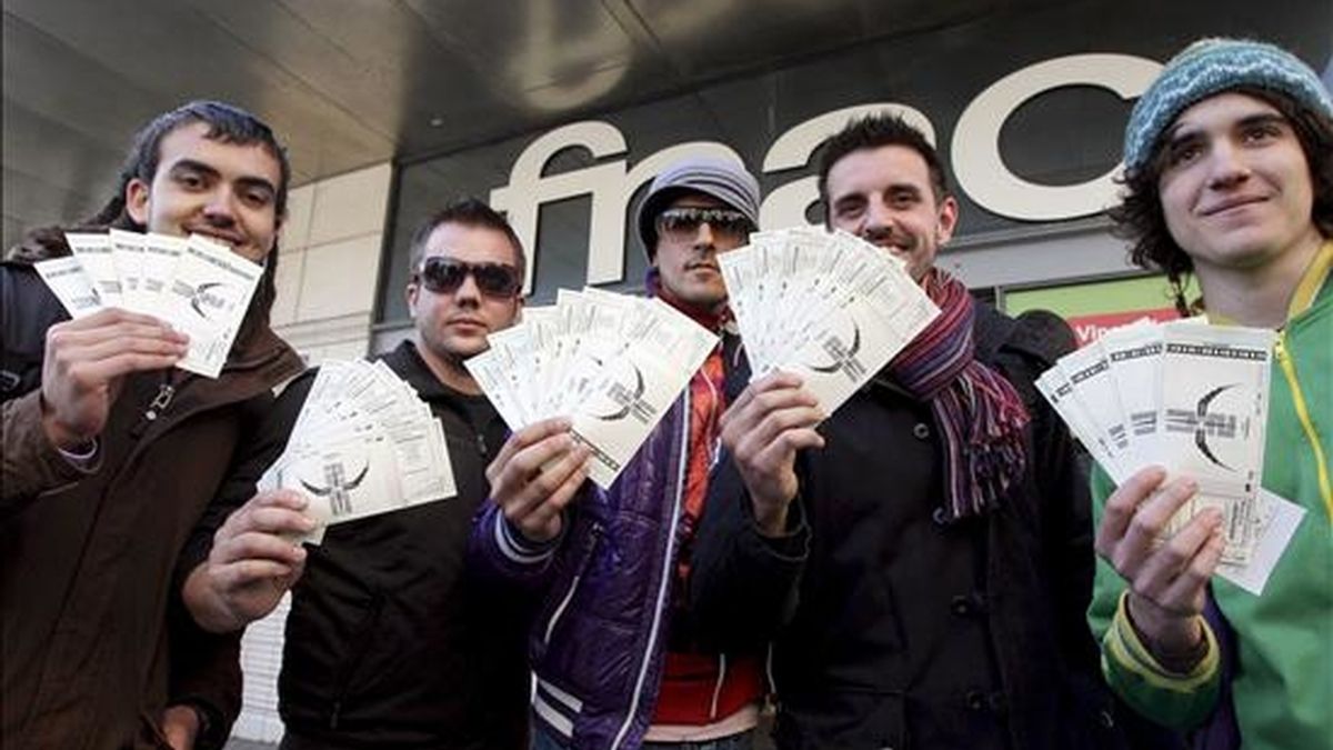 Los primeros compradores de entradas para el concierto que da comienzo a la gira mundial del grupo irlandés U2, el próximo día 30 de junio en Barcelona, muestran el pasado 25 de marzo sus tickets tras hacer 24 horas de cola en unos grandes almacenes de la Ciudad Condal. EFE/Archivo