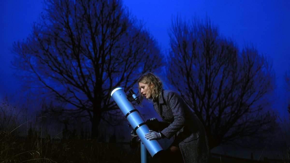 Mujer mira por un telescopio