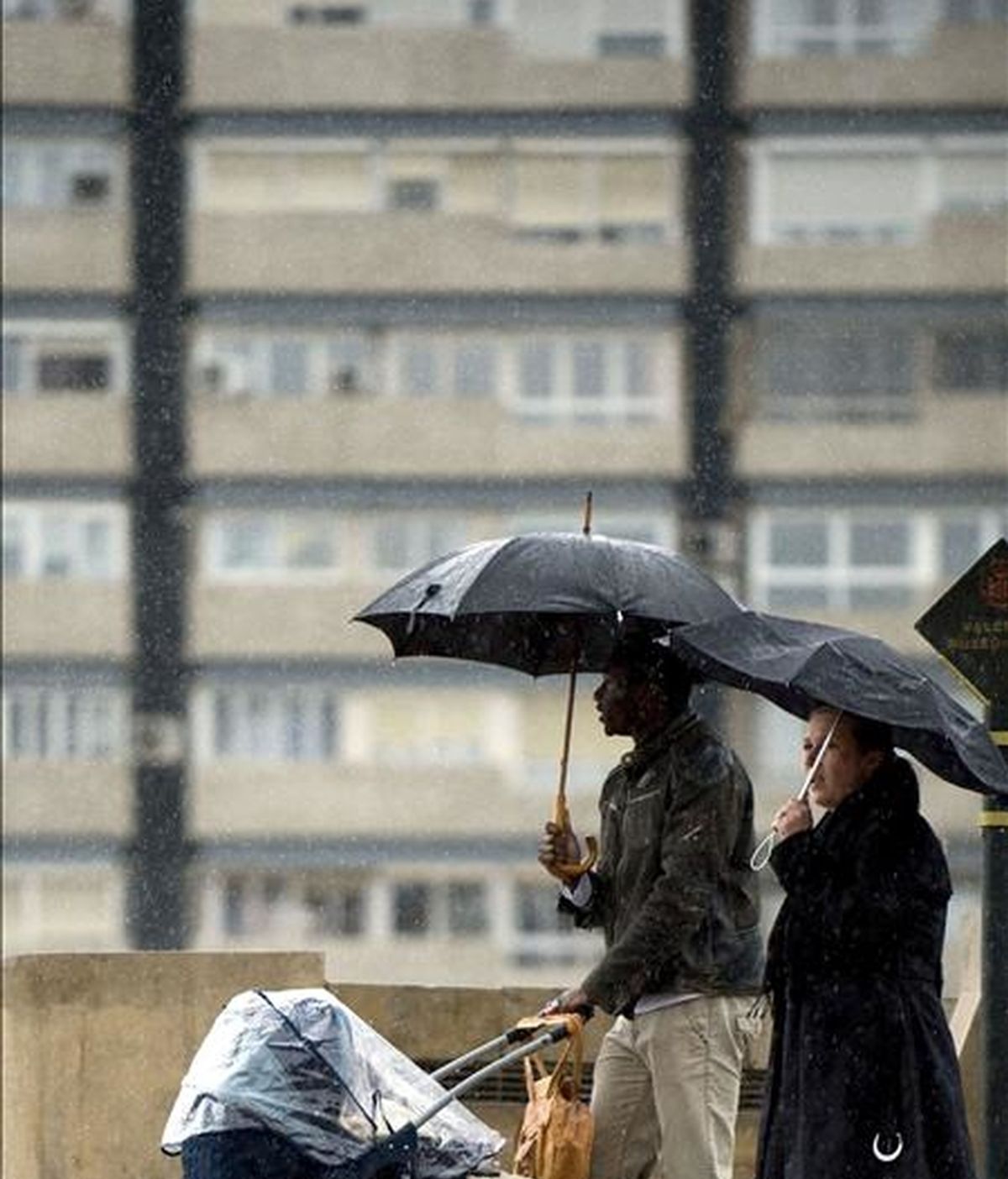 Una familia se protege con un paraguas de la lluvia. EFE/Archivo