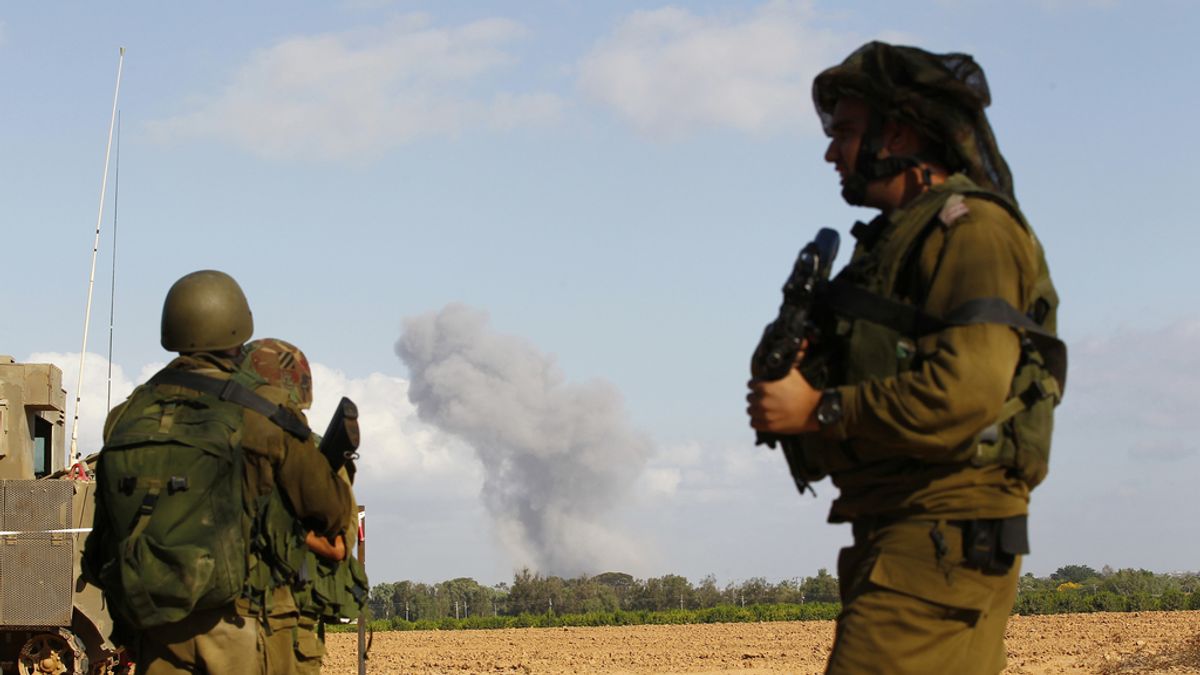 Soldados israelíes observan una columna de humo en Gaza