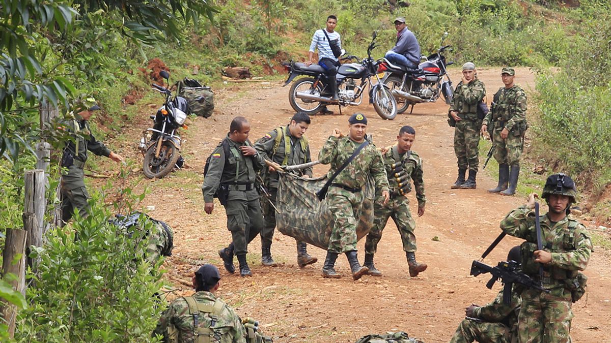 Miembros del ejército recogen los cadáveres de sus compañeros muertos en un enfrentamiento con las FARC