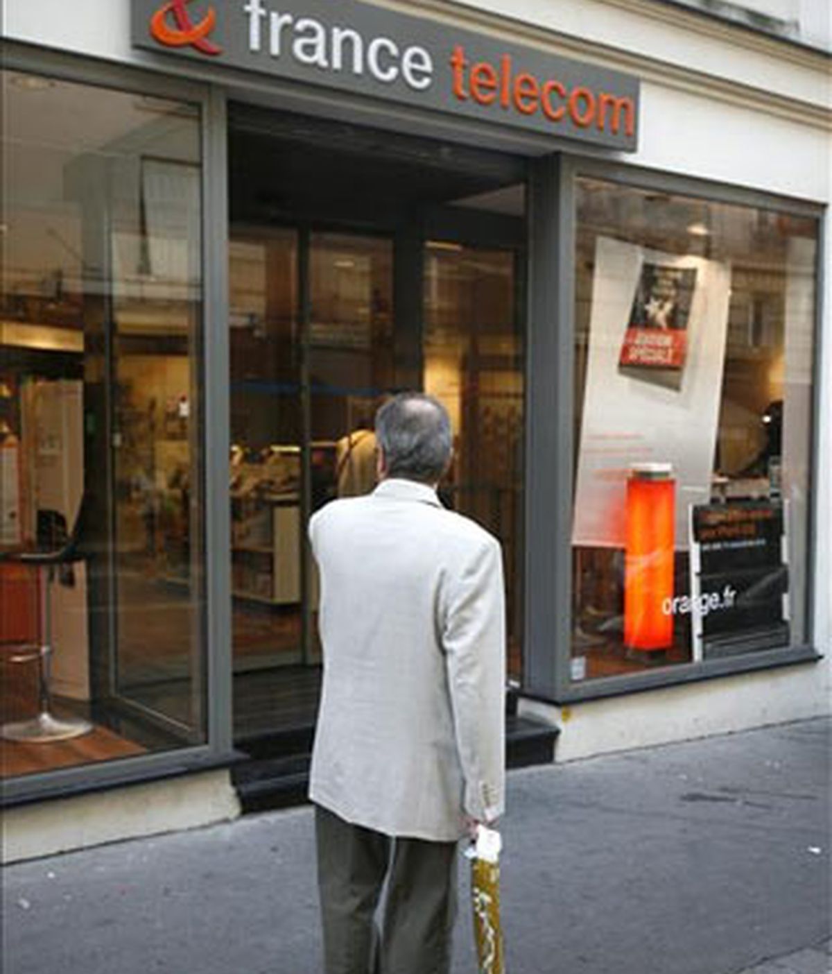 Un hombre camina por delante de una tienda de móviles France Telecom y Orange en París (Francia). EFE