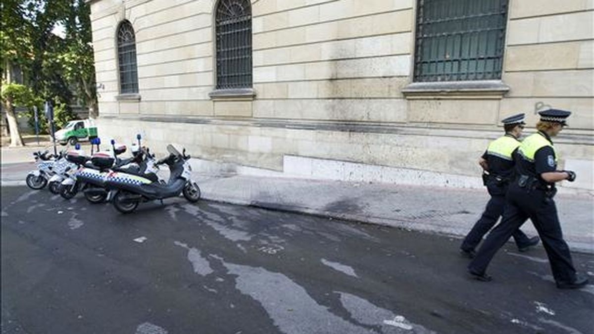 Dos policías municipales pasan junto a un coche atacado con un cóctel molotov en Vizcaya. EFE/Archivo