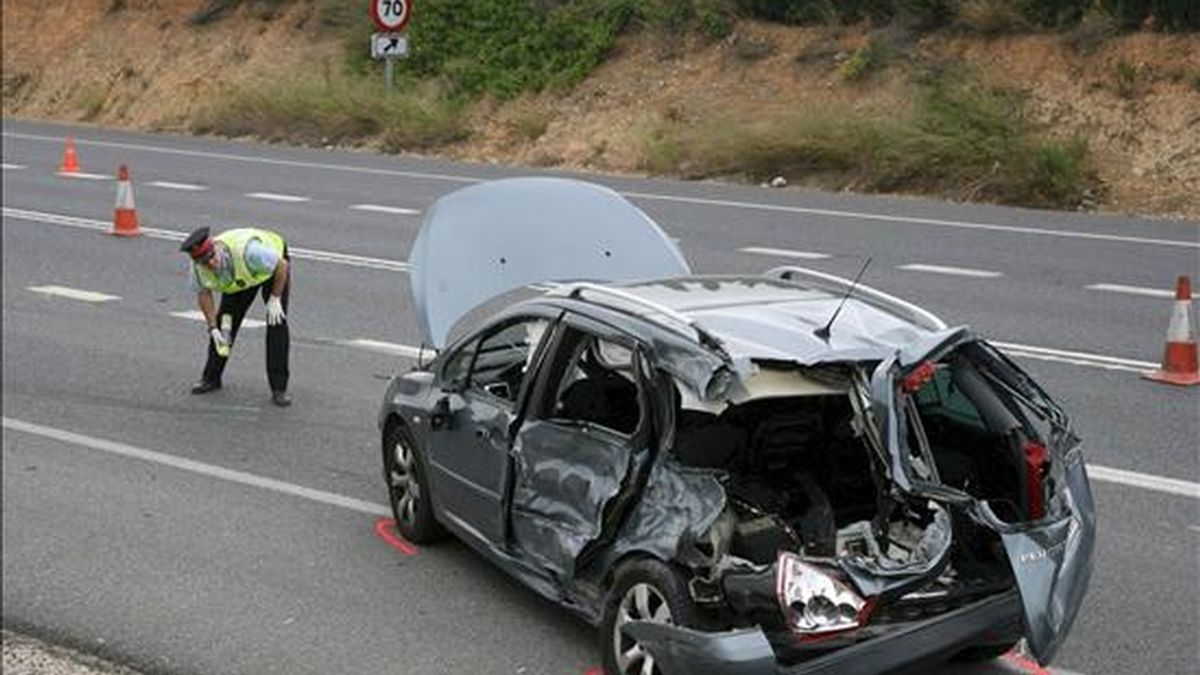 Un guardia civil observa un automóvil que ha sufrido un accidente. EFE/Archivo