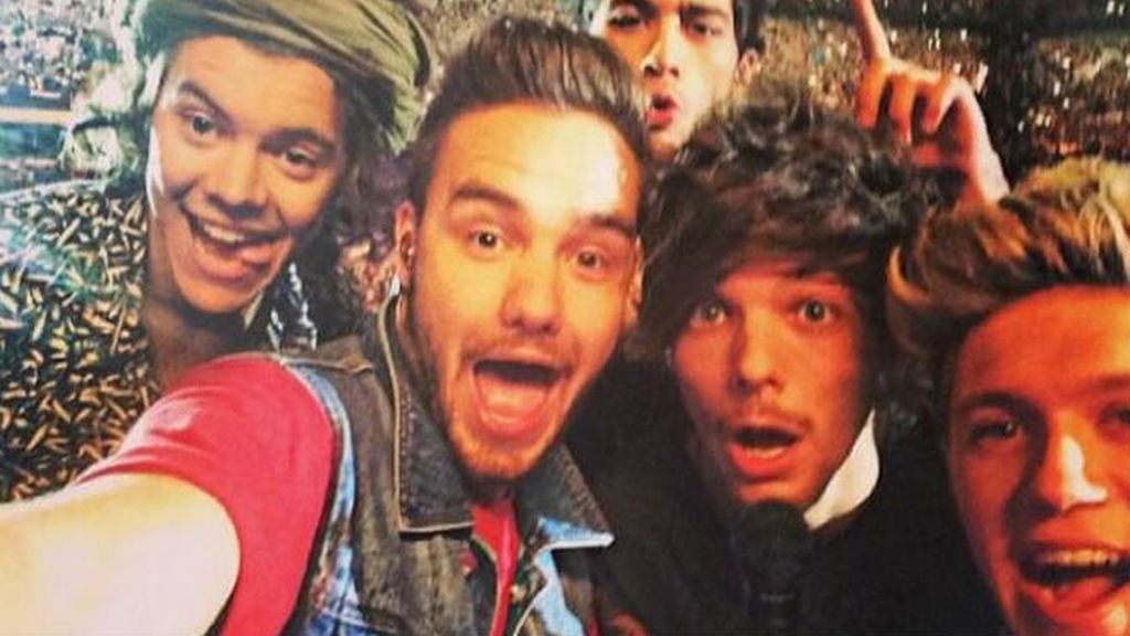 Los cinco One Direction casi no caben en un selfie.... sobre todo si además quieren sacar todos los estadios que llenaron en su gira de 2014