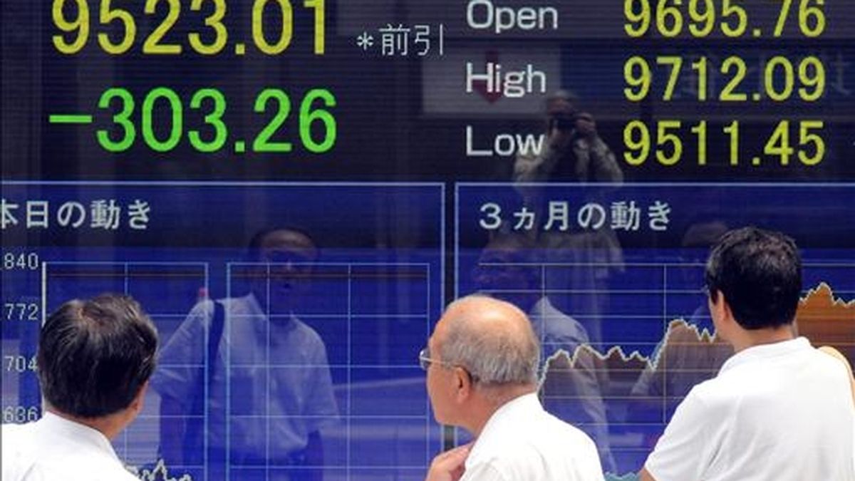 Varios hombres observan el tablero indicador del Nikkei en el centro de Tokio (Japón). EFE/Archivo