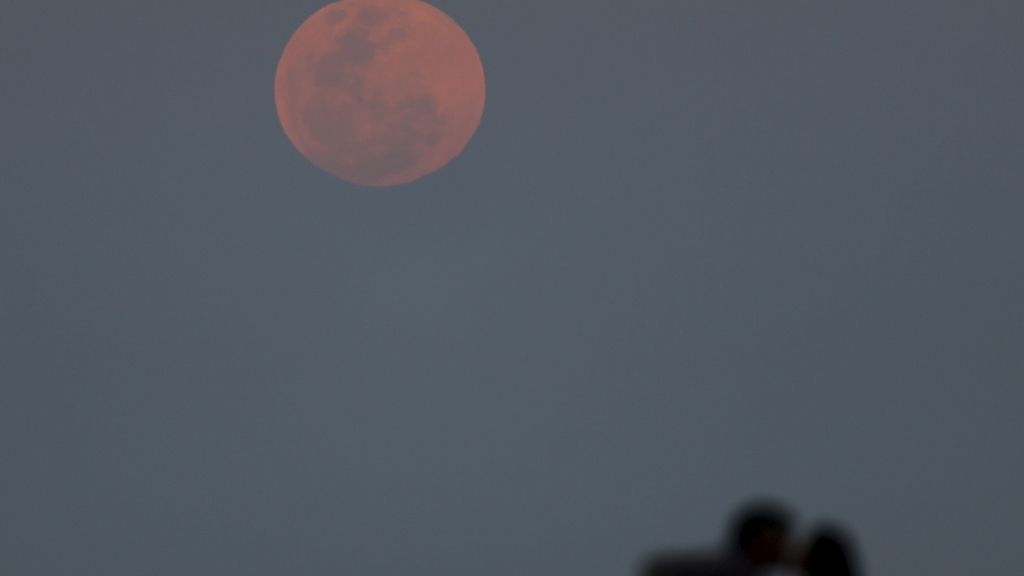 La sombra de una pareja frente a la luna en Río de la Plata, Buenos Aires, Argentina