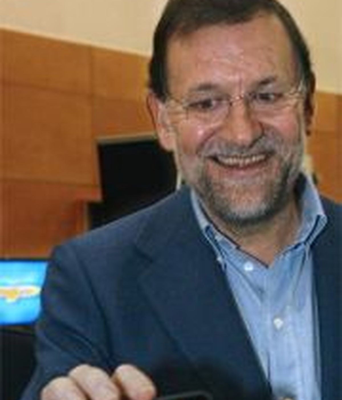 Rajoy sostiene un ipod con un video suyo en la conferencia del PP sobre tecnologías. EFE