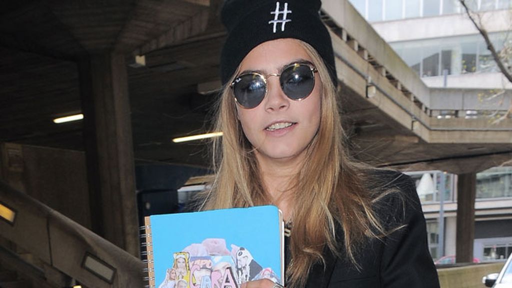 Delevingne completó su estilismo informal con un gorro y gafas de sol
