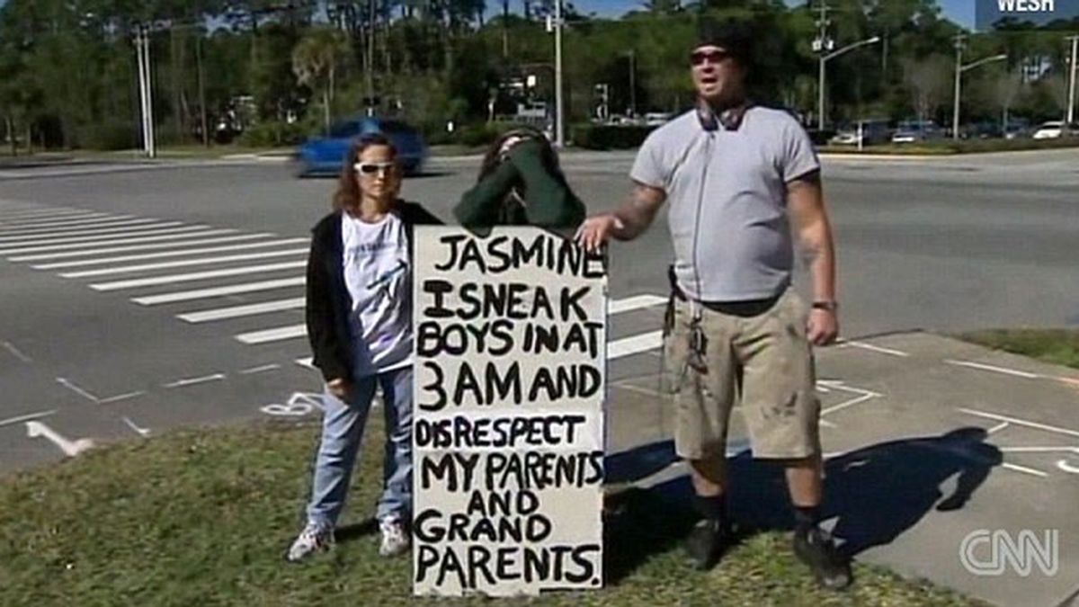 Jasmine con sus padres delante del cartel que informa de su comportamiento