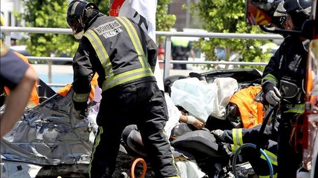 Varios bomberos trabajan sobre un vehículo accidentado en Valencia. EFE/Archivo
