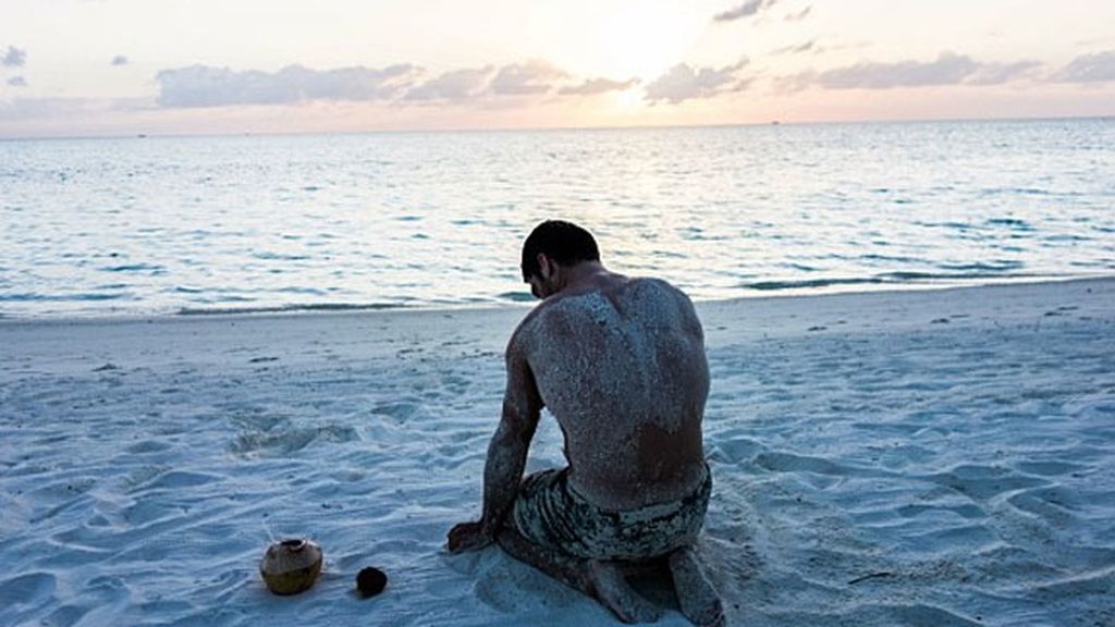 Miguel Ángel, lleno de arena, disfrutando del atardecer en la playa