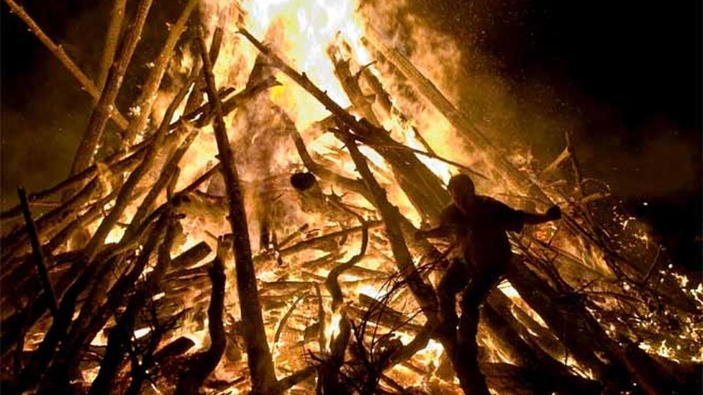 Un hombre salta entre las llamas durante la noche de San Juan en Burgos
