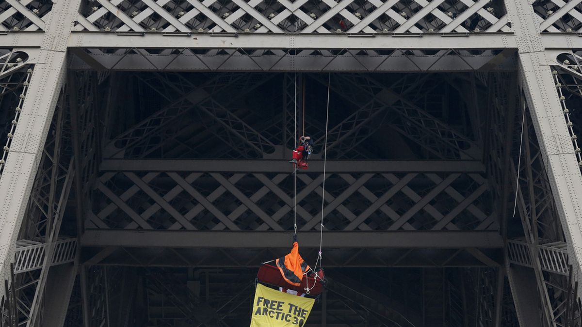 Un activista de Greenpeace se cuelga de la Torre Eiffel