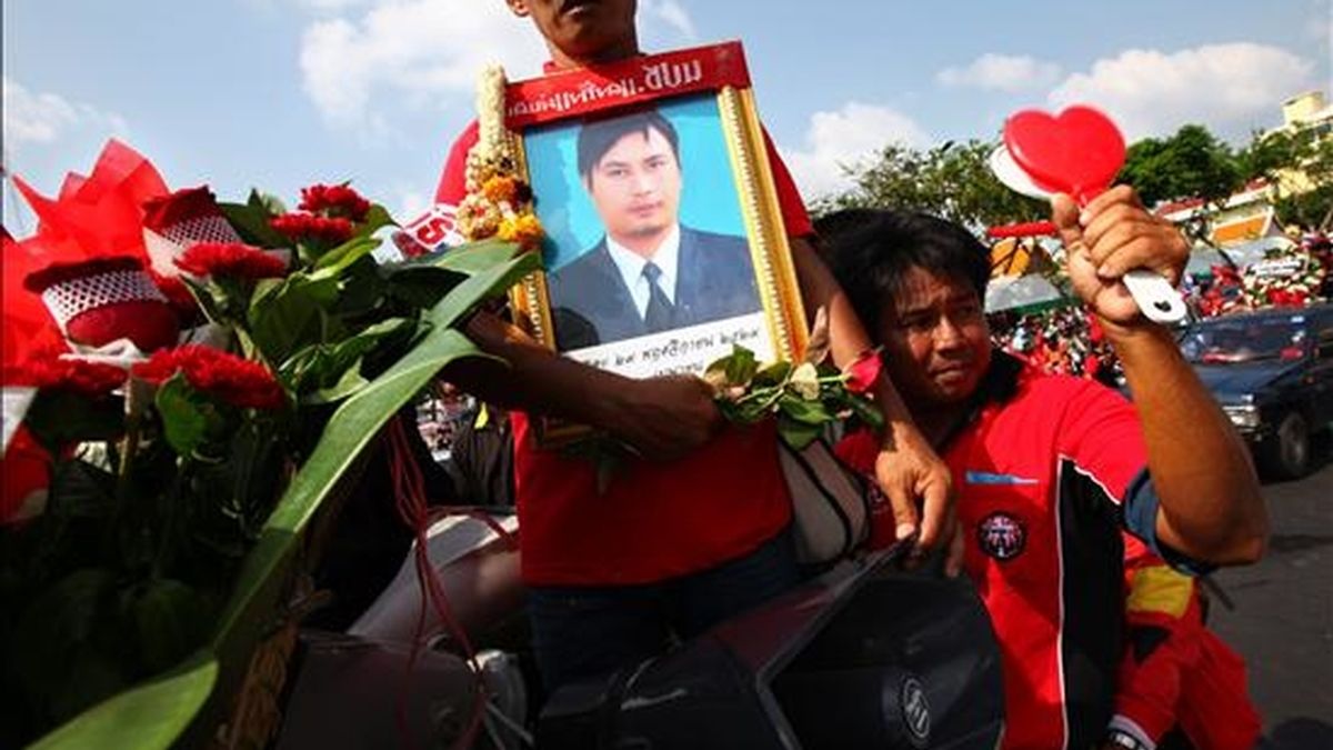 Manifestantes antigubernamentales participan en un funeral que se llevó a cabo con varios camiones que transportaban cofres simbólicos en memoria de los manifestantes que murieron en las calles durante los enfrentamientos con el ejército en Bangkok. EFE