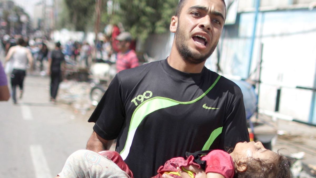 Un hombre palestino con el cadáver de una niña tras el ataque aéreo israelí