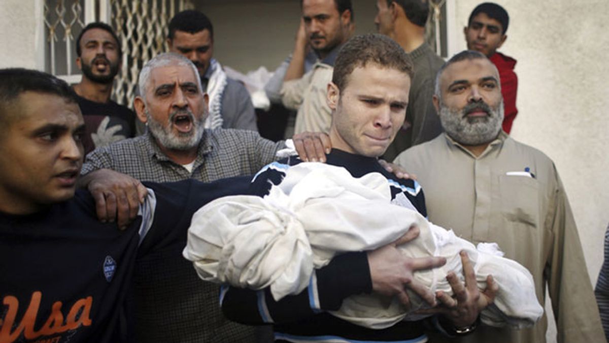 Un padre palestino lleva el cuerpo de su hijo muerto durante un ataque israelí en Gaza