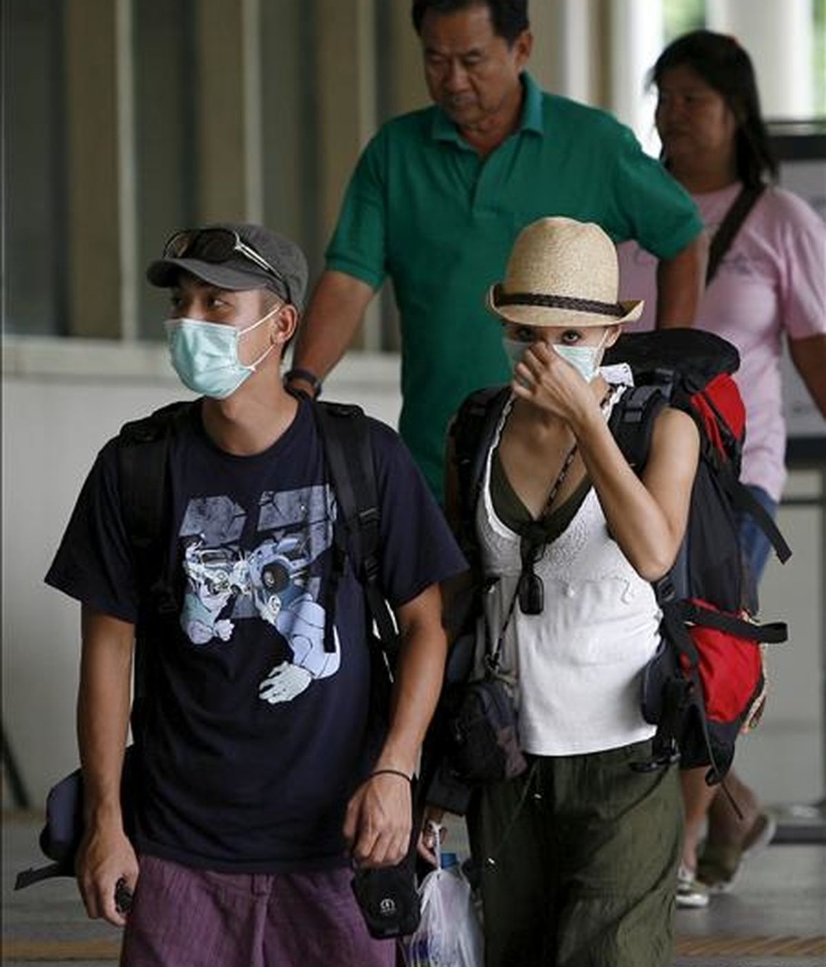 Dos turistas con máscaras caminan por la estación de tren de Bangkok, Tailandia. EFE/Archivo