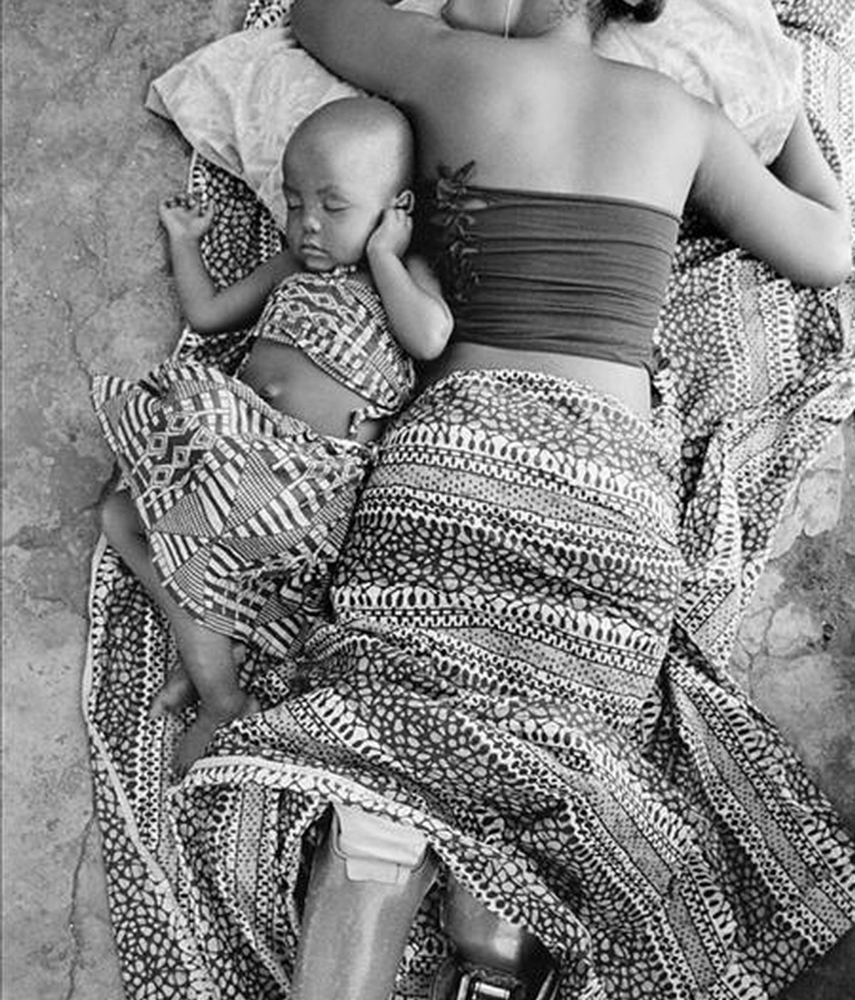 Fotografía tomada en febrero de 2007 por el fotógrafo español Gervasio Sánchez que muestra a Sofía Elface Fumo, quién perdió ambas piernas por una explosión de mina, durmiendo junto a su hija Alia en Massaca (Mozambique). EFE