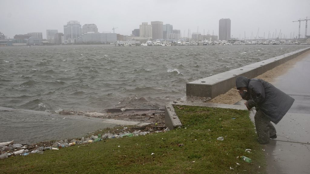 Una mujer se agacha para capear el huracán