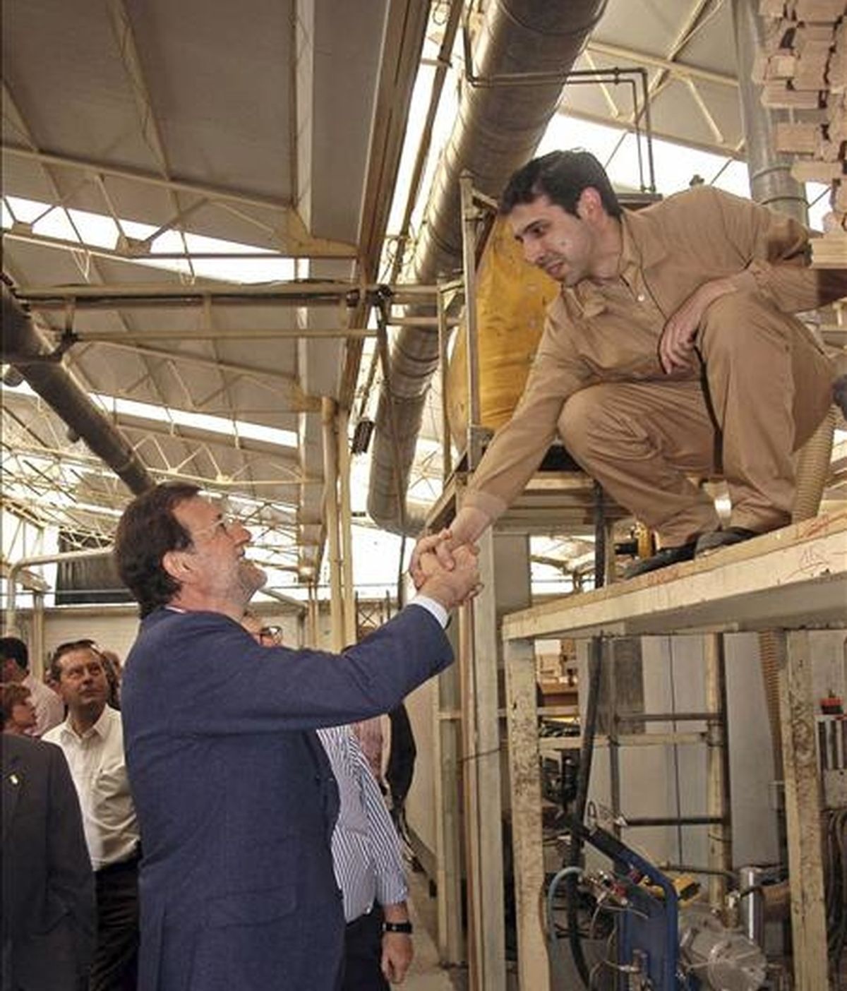 El presidente del Partido Popular, Mariano Rajoy, saluda un trabajador, durante su visita a una fábrica de puertas de la localidad toledana de Villacañas. EFE