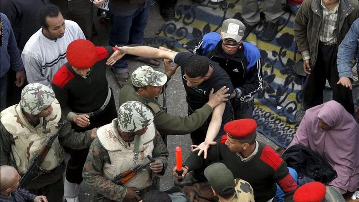 Soldados egipcios intentando frenar hoy a los manifestantes que insistían en no abandonar la plaza cairota Tahrir hasta que el Ejército anunciara un plazo determinado para cumplir con sus peticiones, la primera de ellas la anulación de la ley de Emergencia, vigente desde 1981. EFE