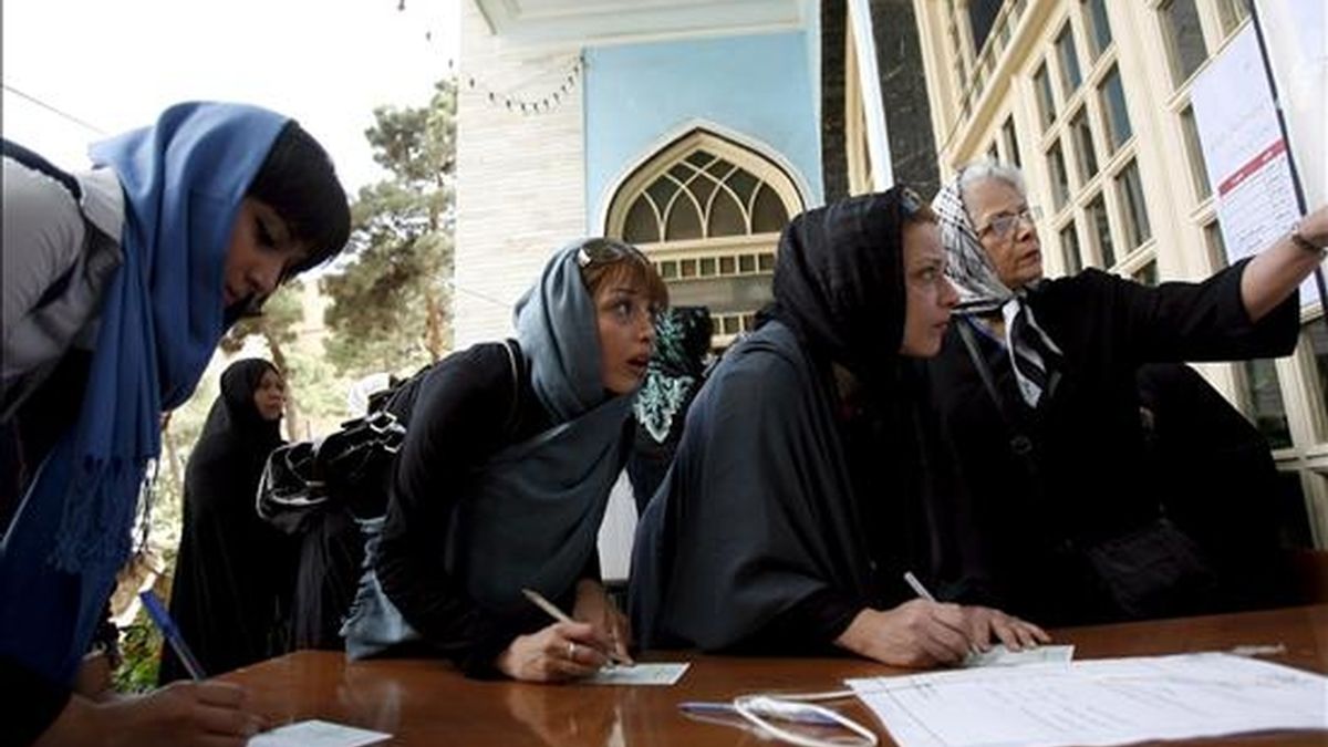 Dos mujeres iraníes votan en un colegio electoral durante la jornada de elecciones presidenciales, en Teherán (Irán), ayer, 12 de junio. El Consejo de Guardianes de Irán informó que la participación fue del 82 por ciento de la población en los comicios de ayer. EFE