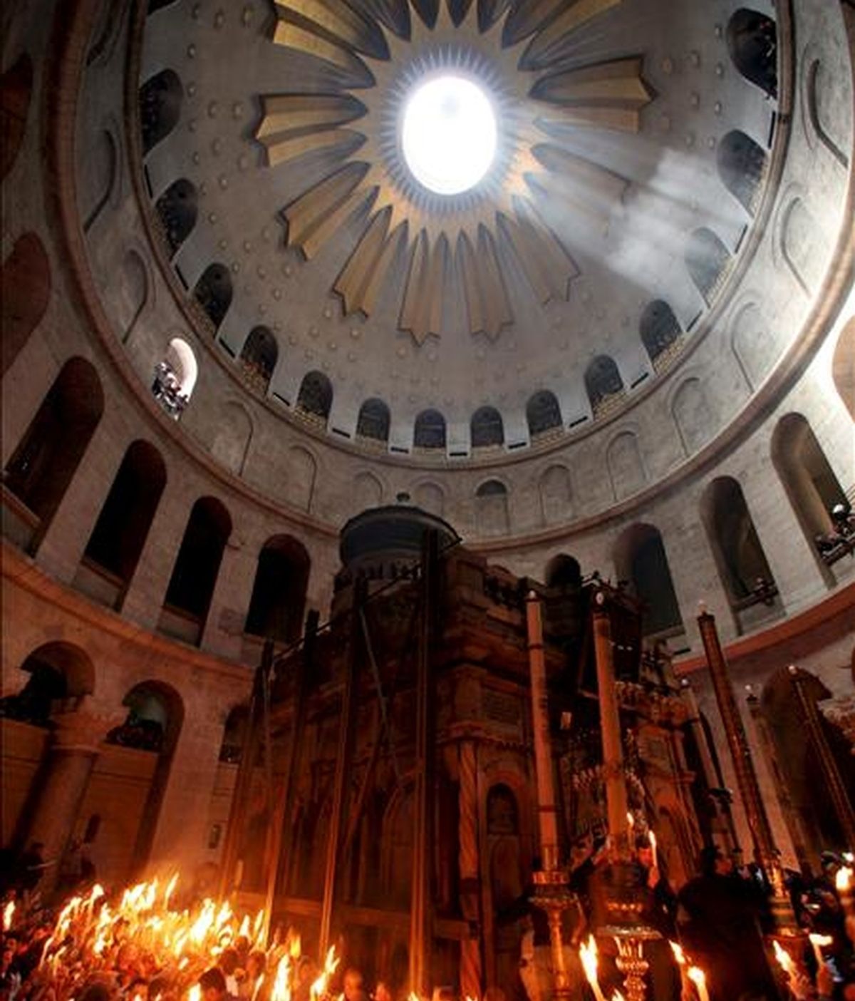 Cristianos ortodoxos encienden velas con fuego procedente de la tumba de Cristo, en el interior de la iglesia del Santo Sepulcro, en Jerusalén (Israel). EFE/Archivo
