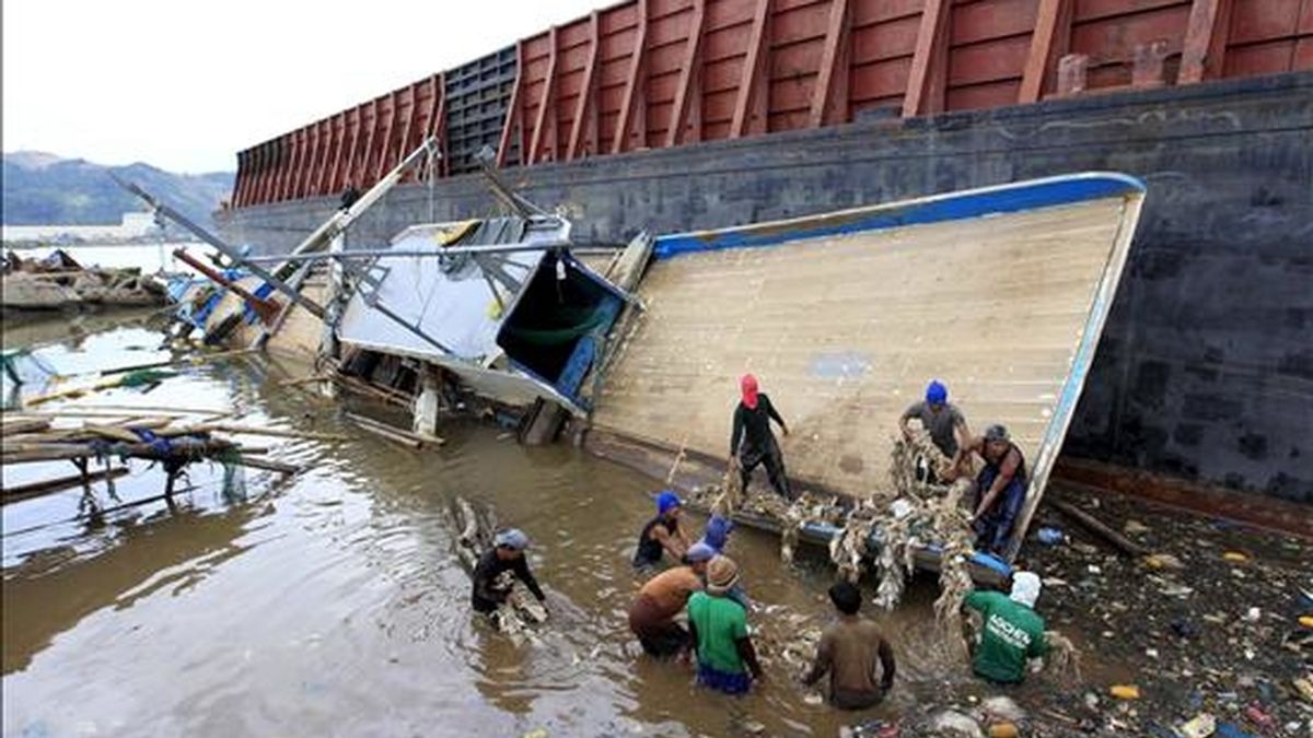 Pescadores filipinos intentan recuperar sus pertenencias de un barco de pesca dañado por el paso del tifón Consón, que ahora se dirige a Vietnam. EFE