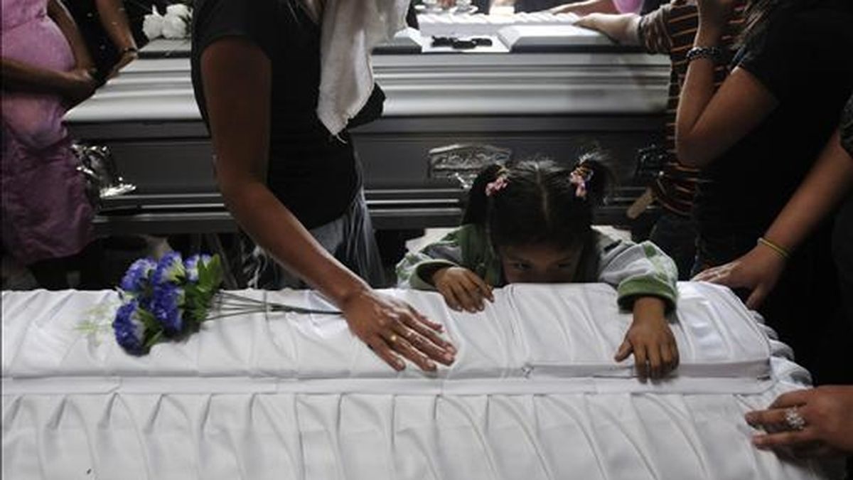 Vecinos y familiares lloran durante el funeral de tres de las siete víctimas mortales del ataque del lunes con una bomba incendiaria en contra de un autobús de transporte público en Ciudad de Guatemala. EFE