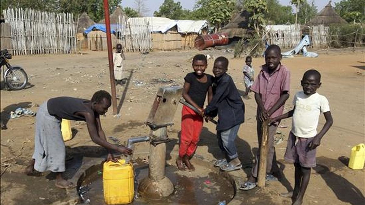 Unos niños ayuda a un hombre recoger agua en Yuba, en el sur de Sudán, hoy, 8 de enero de 2011. Dos décadas de guerra y una complicada transición culminan mañana, 9 de enero de 2011, en el Rederendum de Autodeterminación del Sur, que según todos los pronósticos, determinará el nacimiento de una nueva nación, Sudán del Sur.