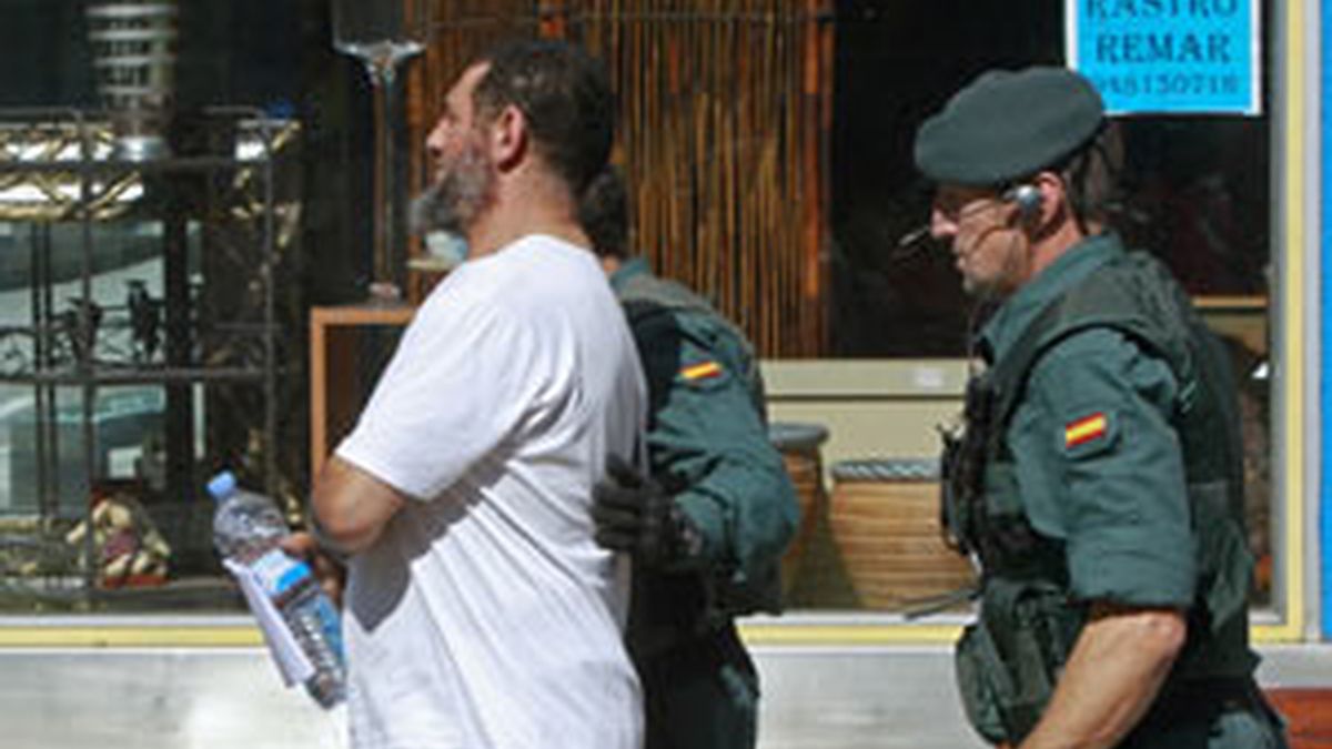 Agentes de la Guardia Civil conducen a uno de los detenidos al regitro de una de las dos carnicerías del barrio pamplonés de San Jorge FOTO: EFE
