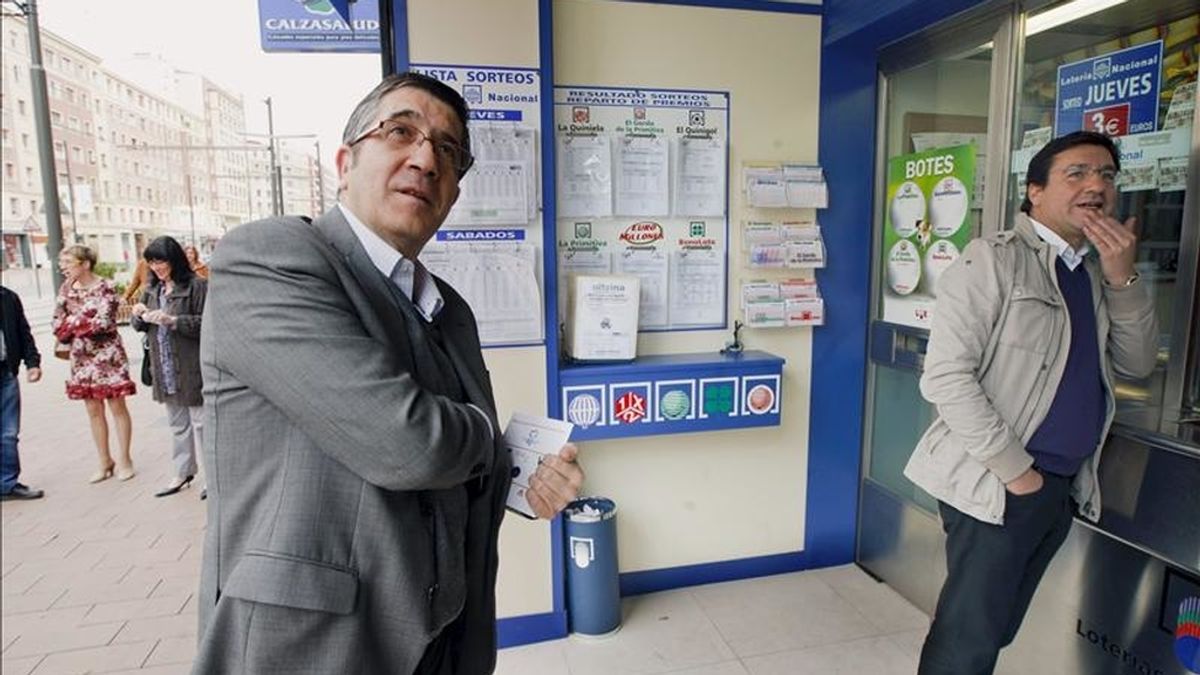 El lehendakari, Patxi López (i), se dispone a comprar lotería en una adminstración del centro de Vitoria, durante el paseo que ha dado hoy con los candidatos a la alcaldía de la ciudad, Patxi Lazcoz (d), y a diputado general, Txali Prieto. EFE
