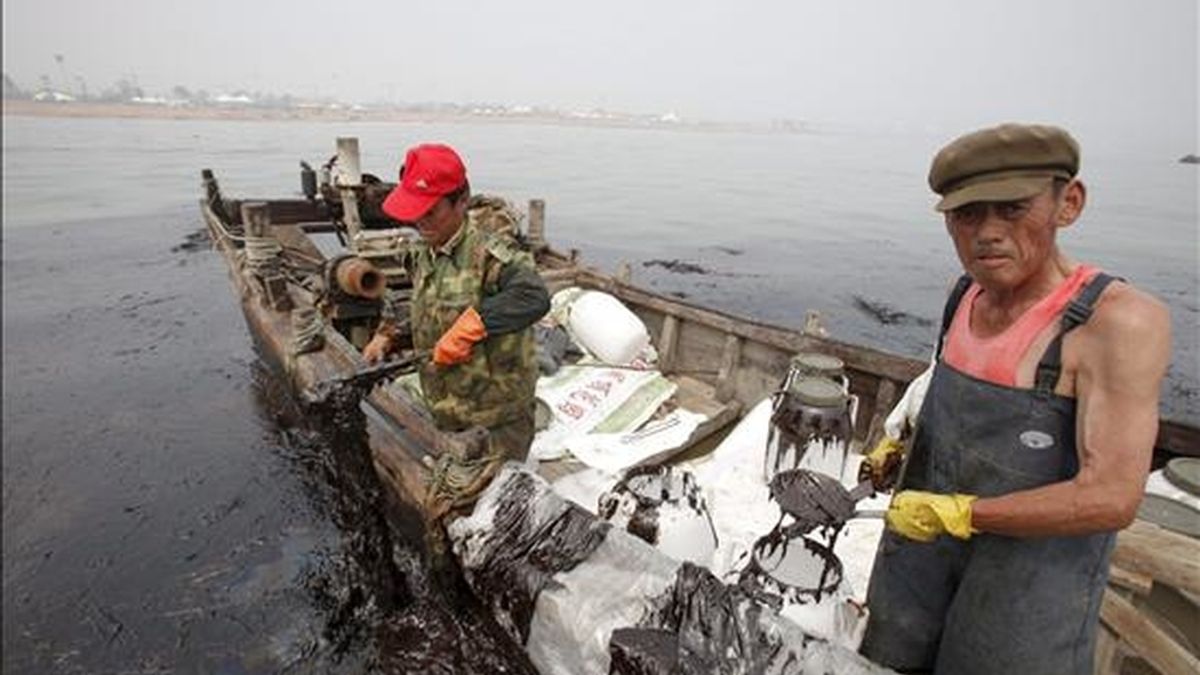 Fotografía facilitada por Greenpeace que muestra las rudimentarias tareas de limpieza del vertido de crudo, en Dalian (China). EFE