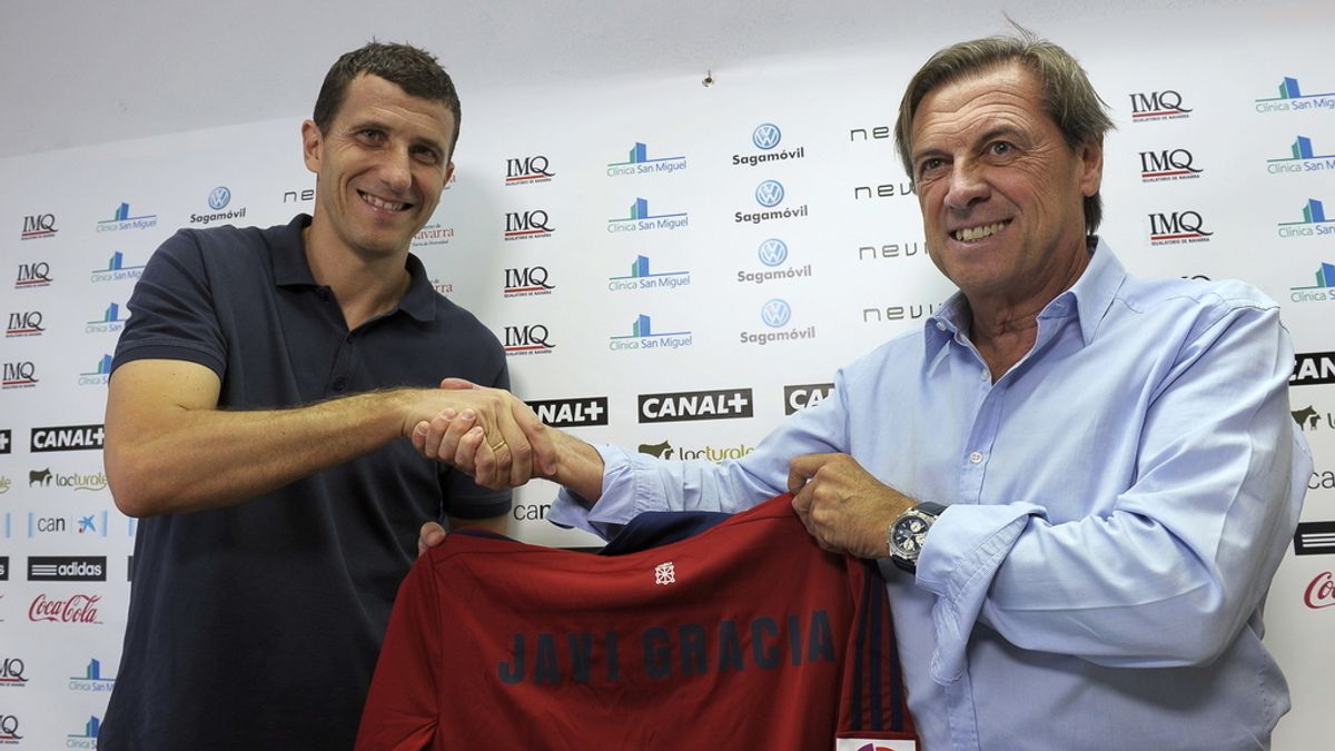 Javier Gracia Carlos (i), estrecha la mano al presidente de Osasuna, Miguel Archanco, durante la presentación oficial como nuevo entrenador del conjunto "rojillo" para las próximas dos temporadas