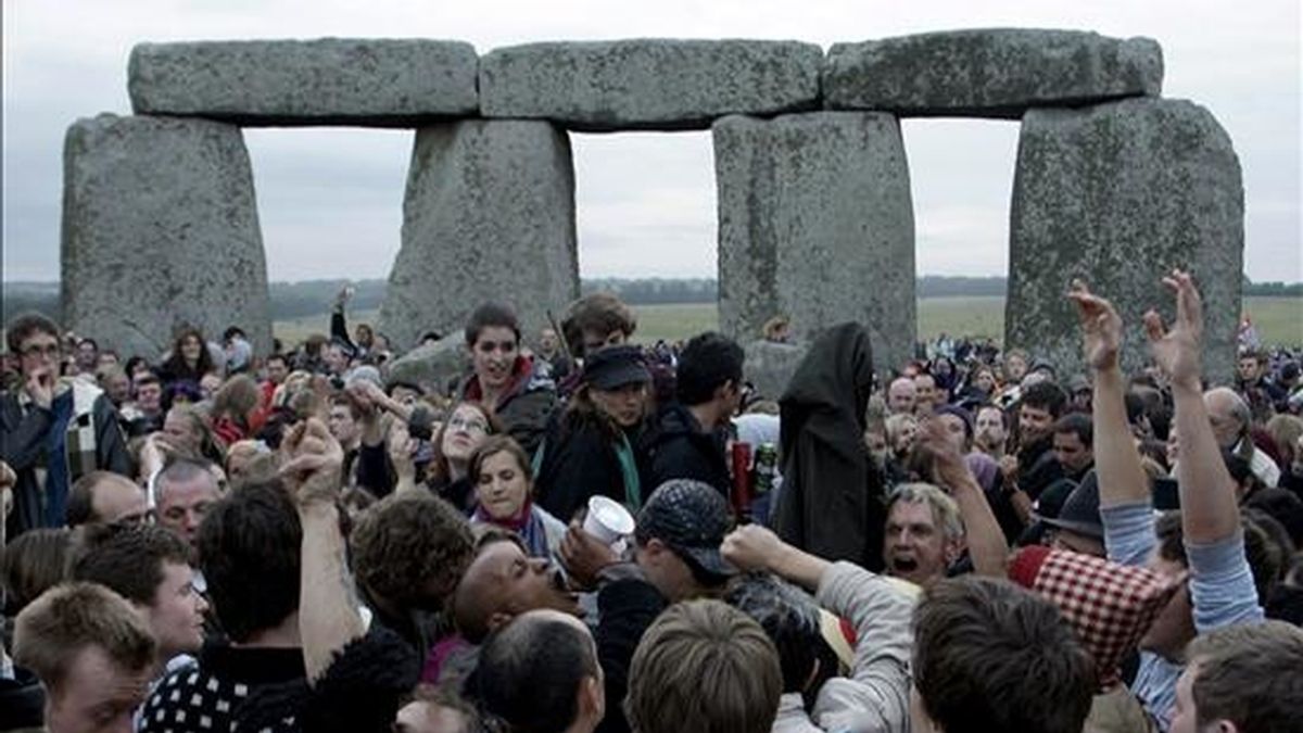 Un grupo de personas se concentra en el conjunto megalítico de Stonehenge para ver el amanecer en la localidad británica de Wiltshire. Miles de ciudadanos han celebrado en este enclave el comienzo del día más largo del año. EFE