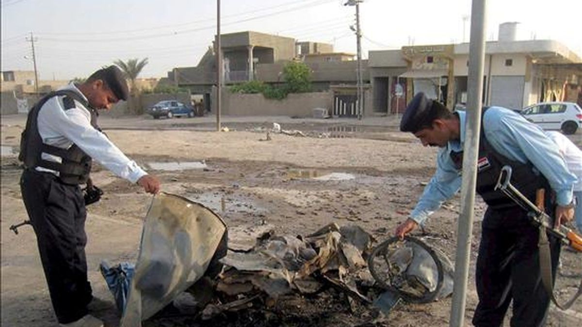 Policías iraquíes inspeccionan los restos de un vehículo utilizado como coche bomba tras un atentado registrado en Kirkuk, en norte de Irak, el 12 de mayo. EFE/Archivo