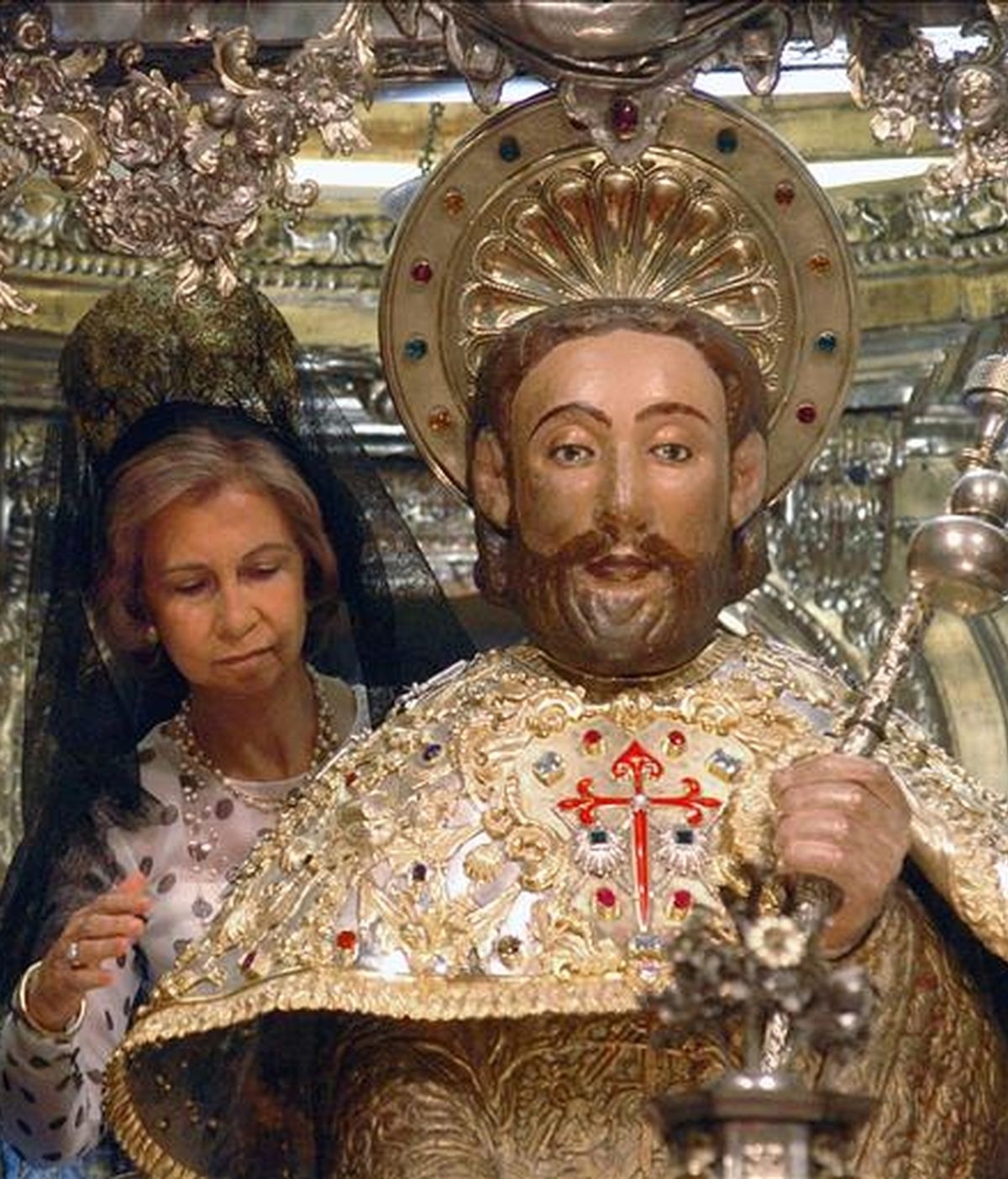 La Reina realiza el rito de los peregrinos de abrazar la imagen del Apóstol Santiago. EFE/Archivo