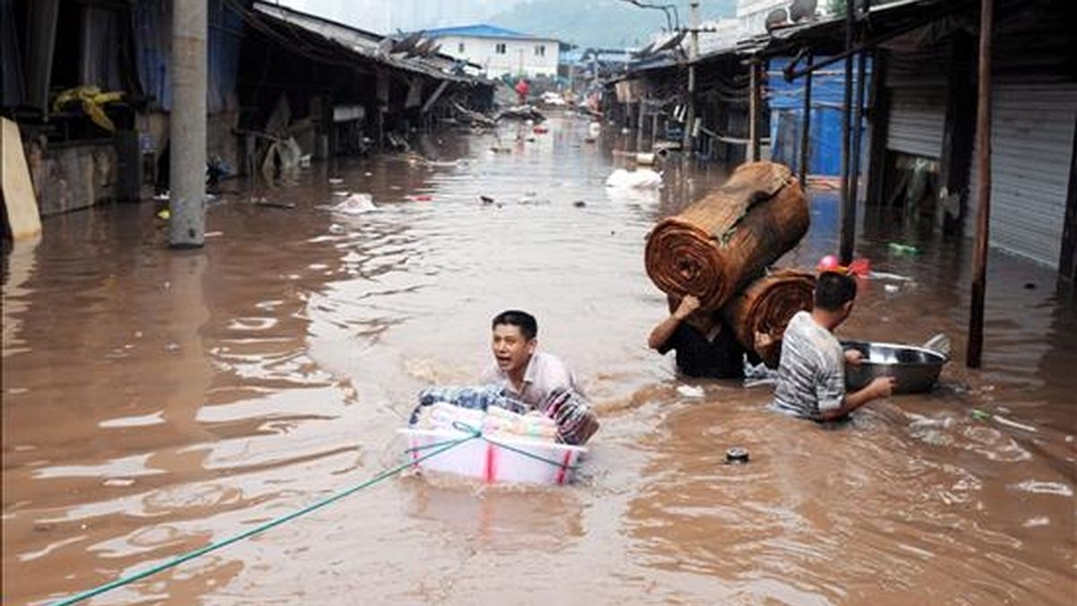 Fotografía tomada el pasado lunes,  en la que un grupo de habitantes de la ciudad de Chongqing, ubicada en el sureste de China, intenta rescatar algunas de sus pertenencias tras las inundaciones causadas por la subida del nivel de agua del río Yangtze. EFE
