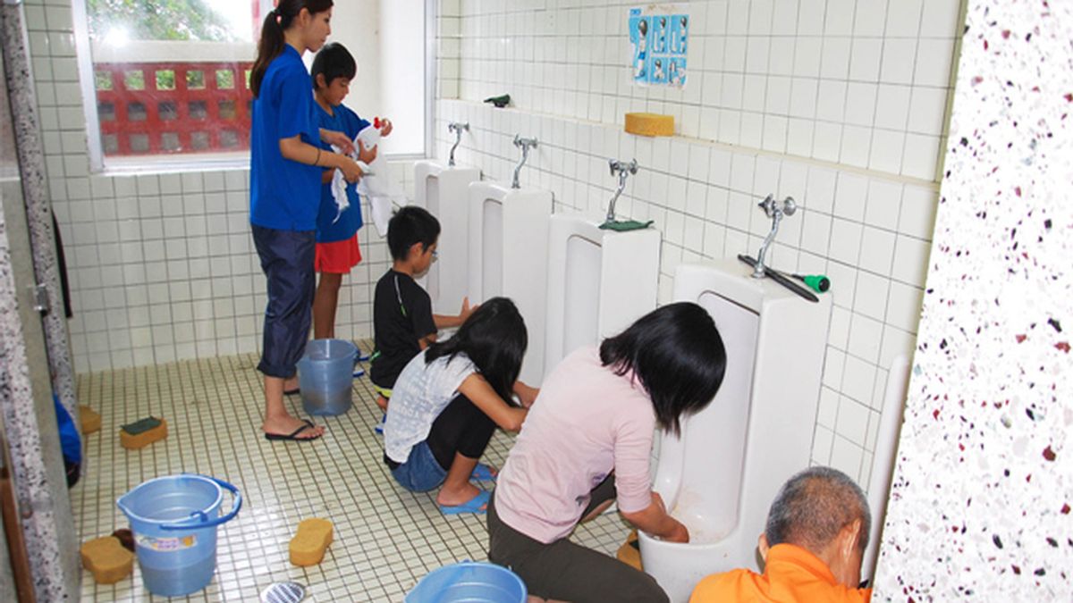 Niños japoneses limpiando los baños de su escuela