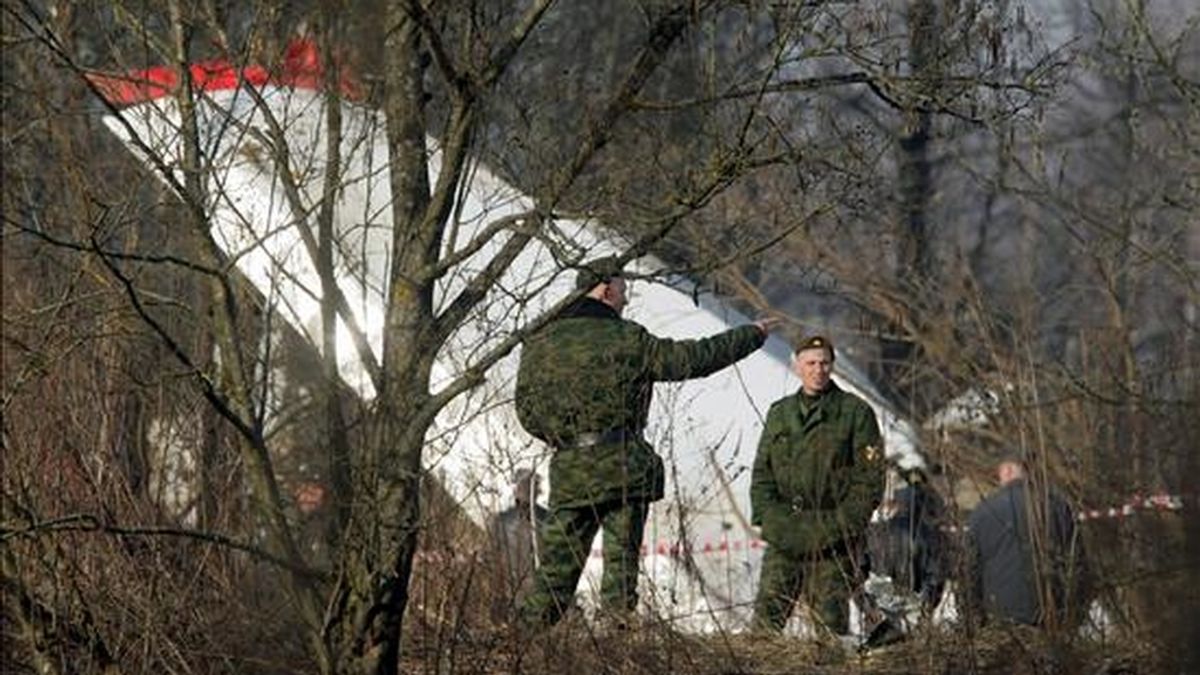Dos oficiales de policía rusos inspeccionan hoy los restos del avión Túpolev-154 en el que viajaba el presidente polaco, Lech Kaczynski, y otras 95 personas, entre ellas más de una veintena de altos cargos políticos y militares, tras el accidente registrado ayer cerca del aeropuerto de Smolensk (Rusia). EFE