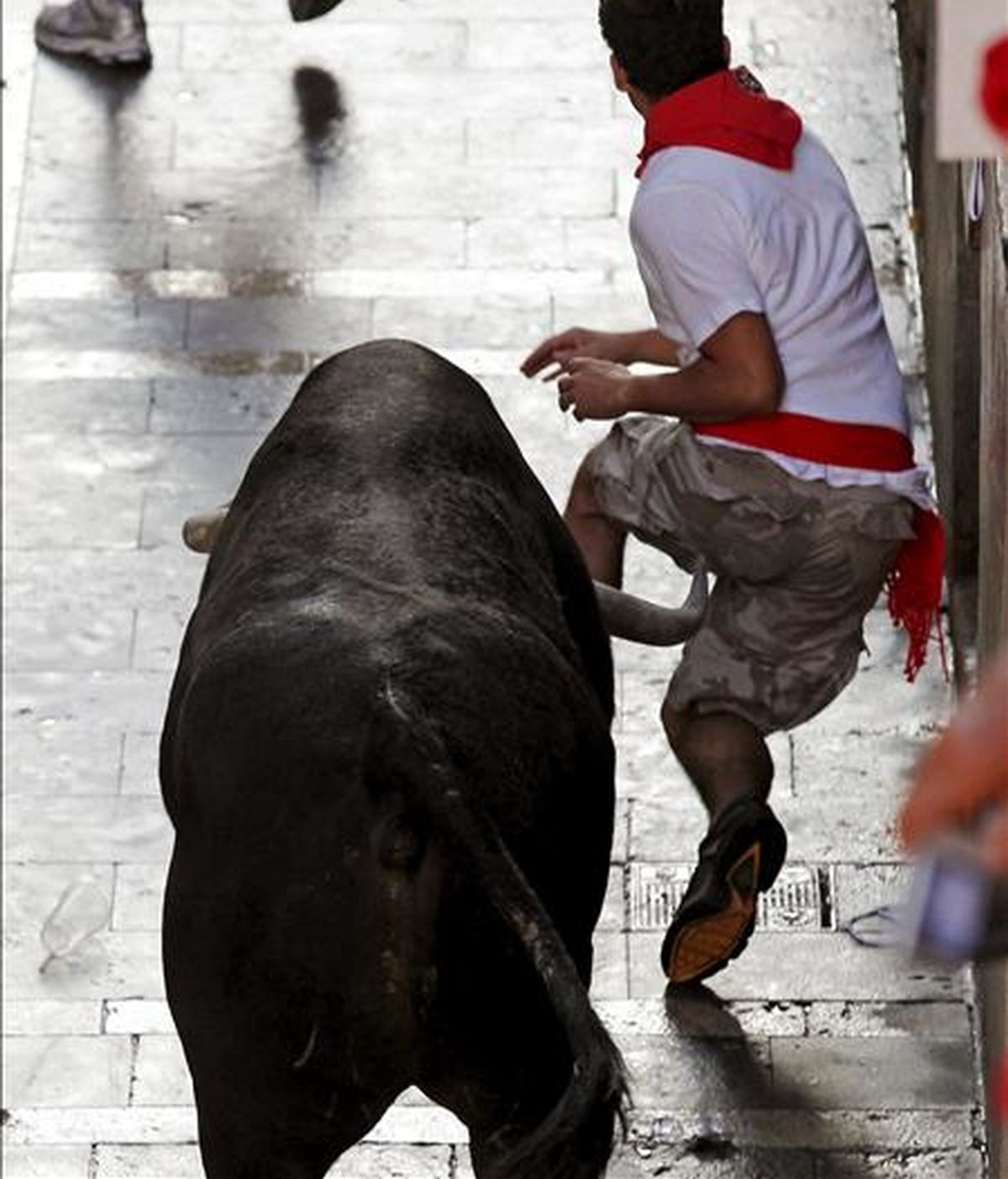 Apuros de un joven en la Calle Mercaderes durante el encierro protagonizado por los toros de la ganadería sevillana de Dolores Aguirre Ybarra, el cuarto de los sanfermines, rápido y peligroso, en el que varios corredores han resultado heridos con traumatismos, aunque ninguno ha sido corneado. EFE