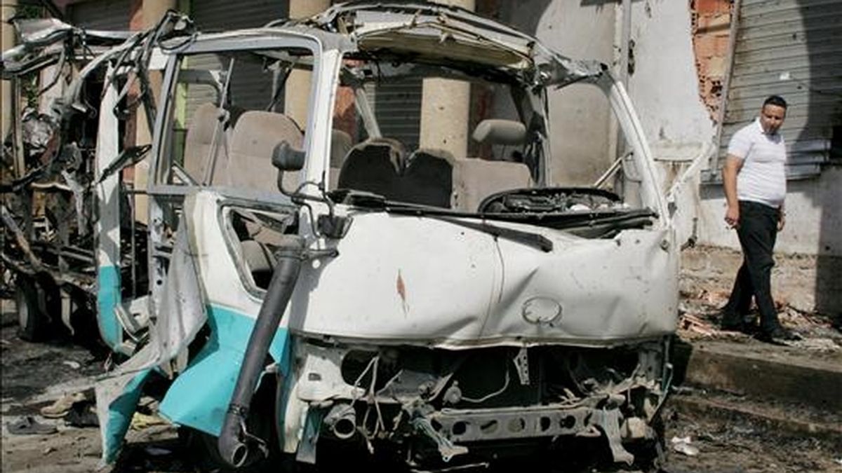 Un argelino pasa junto a un autobús destruido en un atentado suicida perpetrado en la ciudad de Bouira, a 120 km al este de Argelia. EFE/Archivo