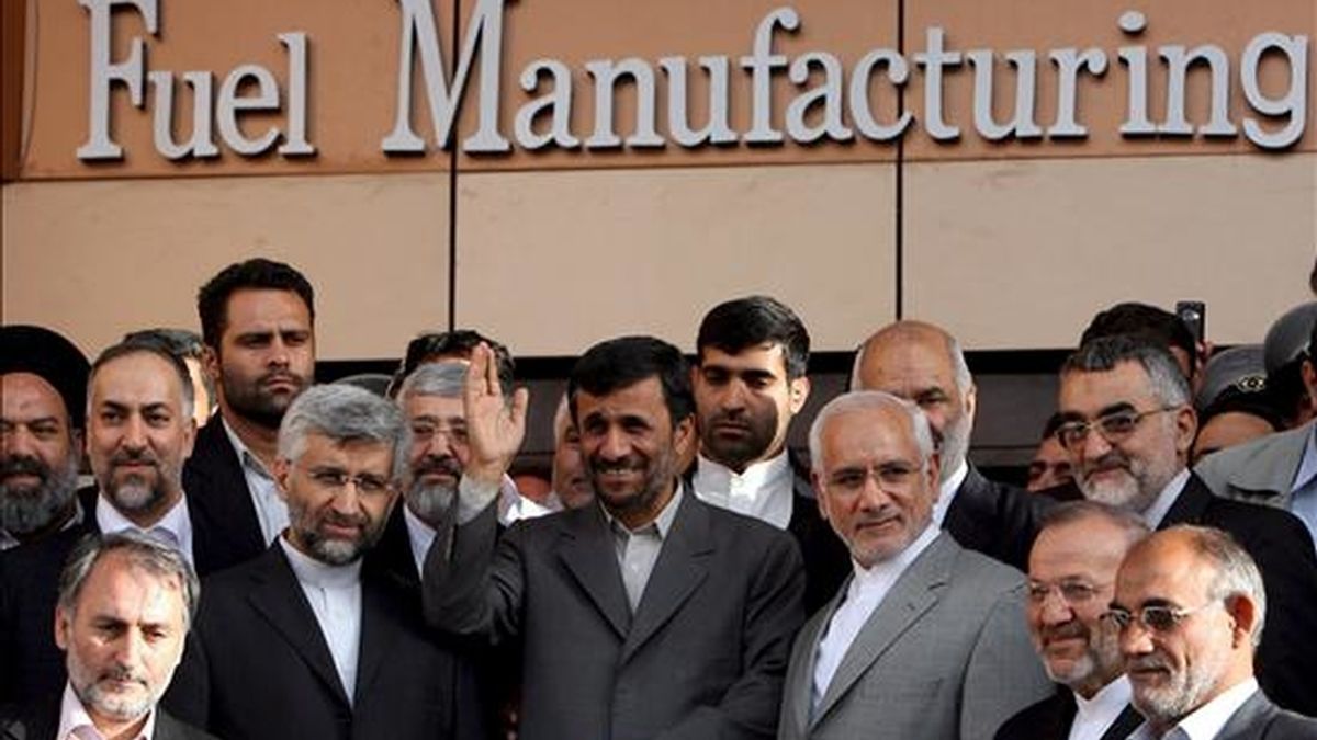 El presidente iraní, Mahmud Ahmadineyad (c), rodeado de científicos iraníes, durante la inauguración el primer aparato en el que se concentran las pastillas de combustible nuclear y que pondrán en funcionamiento el reactor nuclear que se construye en Arak. EFE