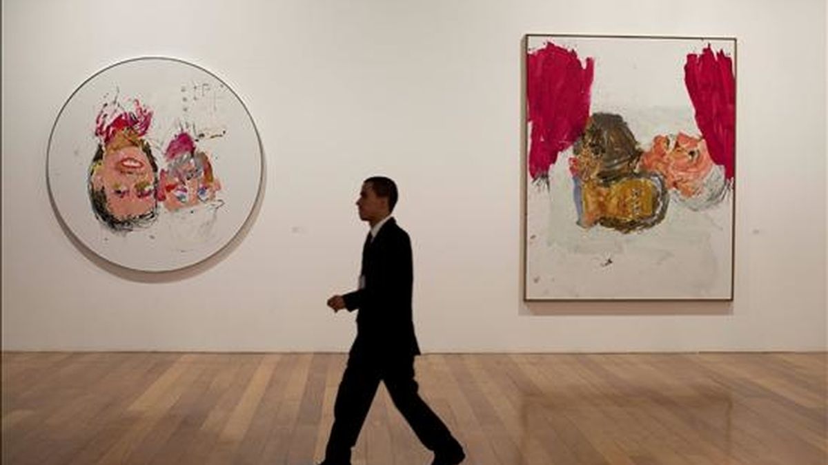 Un hombre camina frente a dos obras que hacen parte de la exposición "Georg Baselitz: Pinturas Recientes" del artista alemán Georg Baselitz este 7 de diciembre en la Pinacoteca en Sao Paulo (Brasil). EFE