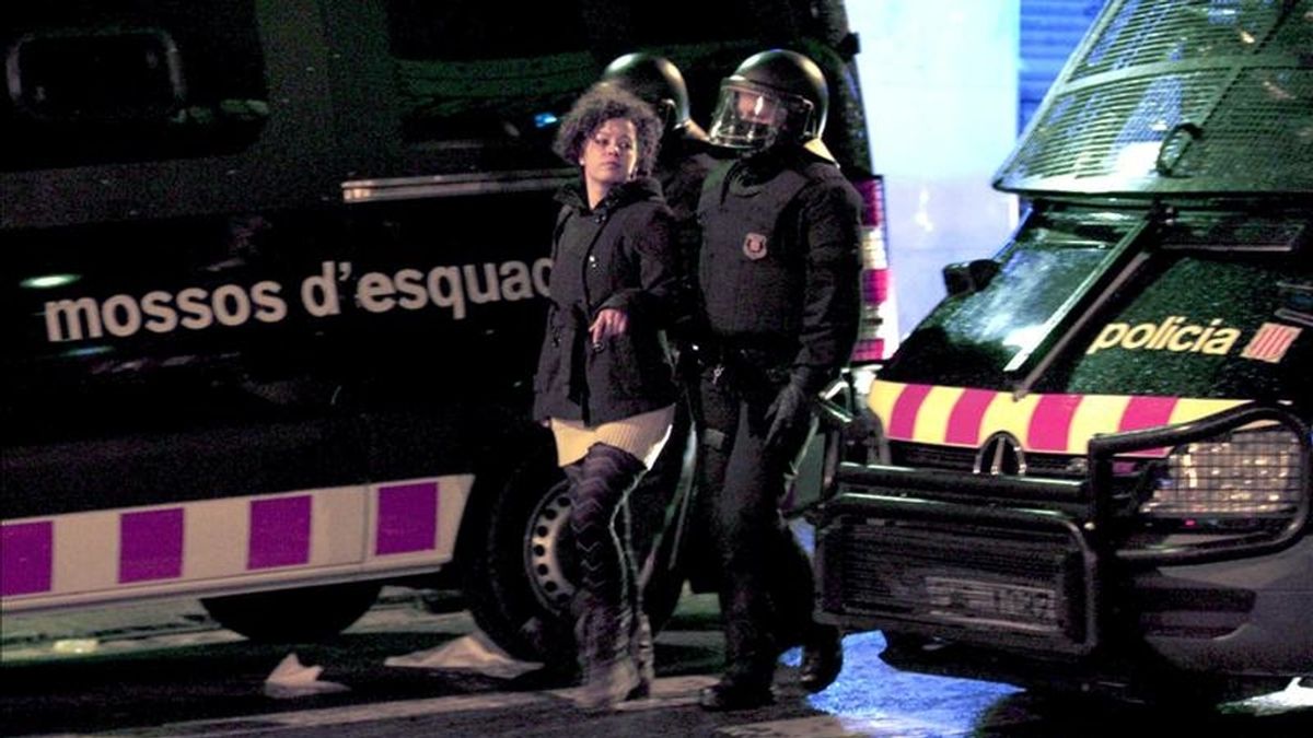 Los mossos d'esquadra desalojan a uno de los manifestantes que ocuparon este sábado unos antiguos cines abandonados en la Via Laietana de Barcelona. EFE