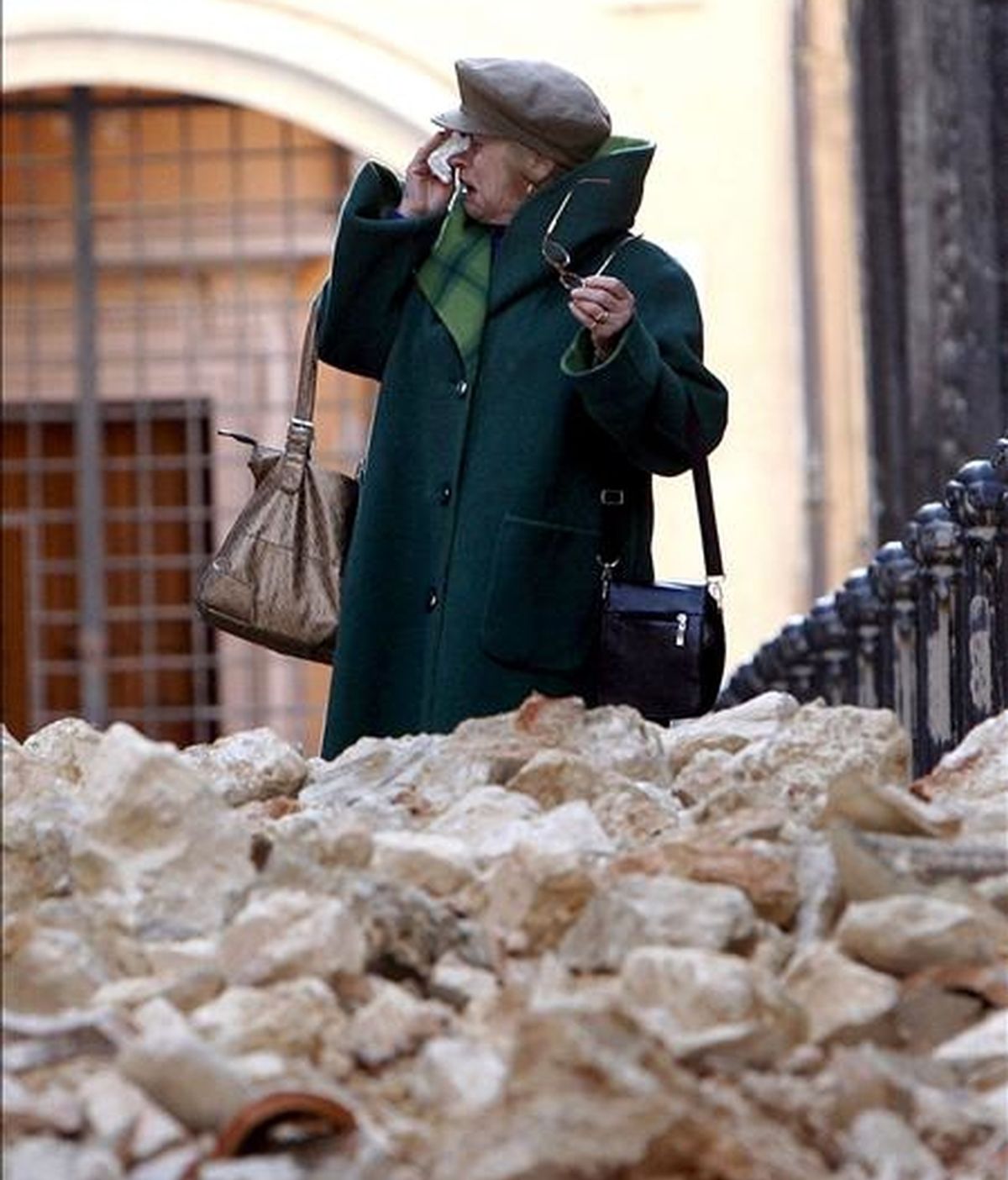Una mujer llora junto a una pila de escombros en la ciudad italiana de L'Aquila, tras el terremoto del día 6. EFE