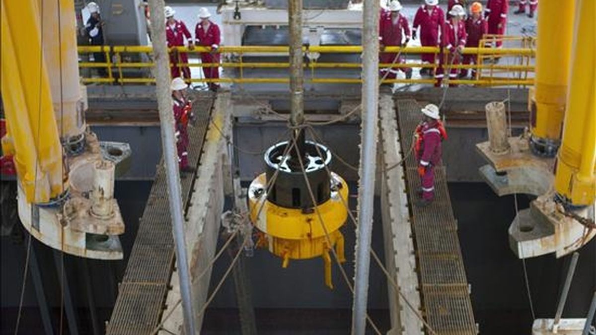 Imagen cedida este 11 de julio por BP que muestra a varios trabajadores abordo del Transocean Discoverer Inspiration mientras los robots submarinos de BP retiran la campana de contención que capturaba parte del petróleo que se escapa al Golfo de México. EFE