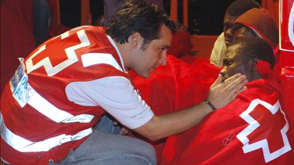 Un miembro de la Cruz Roja se interesa por el estado de uno de los 38 inmigrantes que llegó en 2009 al puerto de Almería tras ser rescatados de la patera en la que viajaban por Salvamento Marítimo. EFE/Archivo