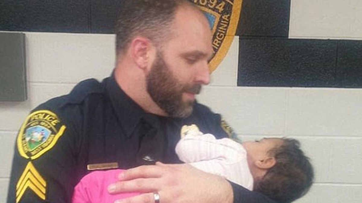 Un policía cuida de un bebé que rescató del baño de una tienda